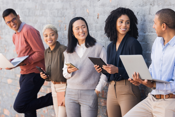 A diverse group of five people waiting to speak to recruiters or a hiring team